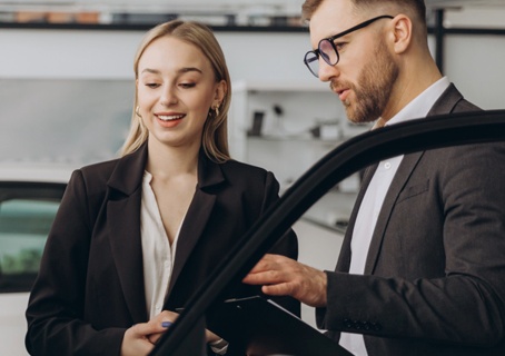 Salesperson showing a customer a vehicle during an in-store trade-in appraisal in Mesa, AZ
